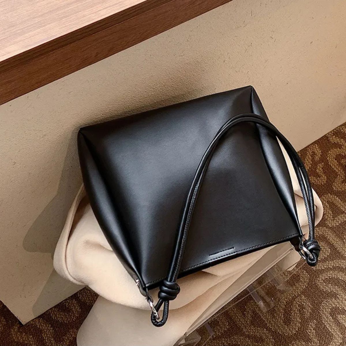 Close up of magnetic closure on umber black shoulder bag