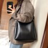 Woman carrying umber black shoulder bag for office use