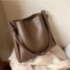 Close up of magnetic closure on umber brown shoulder bag
